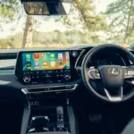 Lexus RX 450h+, cabine da versão internacional; volante, acabamento e equipamentos podem diferir no Brasil.