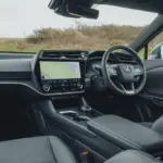 Lexus RZ 500e, cabine da versão internacional; volante, acabamento e equipamentos podem diferir no Brasil.