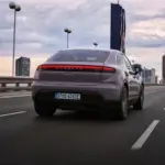 Vista traseira em movimento da família Porsche Macan Electric